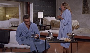 Movie still from “Dr. No” (1962), directed by Terence Young – A man and a woman drinking coffee in a room; Wide shot, High angle