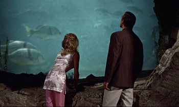 Movie still from “Dr. No” (1962), directed by Terence Young – A man and a woman looking at a fish tank; Wide shot, High angle