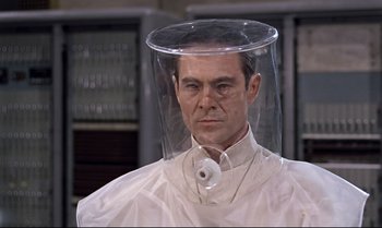 Movie still from “Dr. No” (1962), directed by Terence Young – A man wearing a protective face shield and a white shirt; Close Up shot, High angle