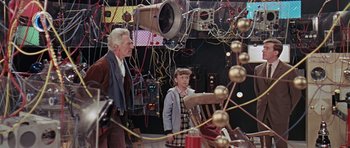 Movie still from “Dr. Who and the Daleks” (1965), directed by Gordon Flemyng – An older man and a young girl in a room; Medium shot, High angle