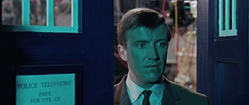 Movie still from “Dr. Who and the Daleks” (1965), directed by Gordon Flemyng – A person wearing a suit and tie; Close Up shot, Over the shoulder angle