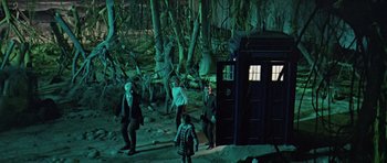Movie still from “Dr. Who and the Daleks” (1965), directed by Gordon Flemyng – A group of people standing next to each other in a forest; Extreme Wide shot, High angle