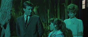 Movie still from “Dr. Who and the Daleks” (1965), directed by Gordon Flemyng – A man in a suit talking to a young girl; Medium shot, Over the shoulder angle