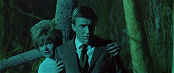 Movie still from “Dr. Who and the Daleks” (1965), directed by Gordon Flemyng – A man in a suit and tie standing next to a tree; Medium shot, Low angle