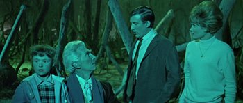 Movie still from “Dr. Who and the Daleks” (1965), directed by Gordon Flemyng – Two men in suits talking in the woods; Medium shot, Over the shoulder angle