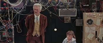 Movie still from “Dr. Who and the Daleks” (1965), directed by Gordon Flemyng – An older man and a young boy in a room; Medium shot, Over the shoulder angle
