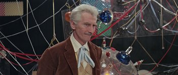 Movie still from “Dr. Who and the Daleks” (1965), directed by Gordon Flemyng – An older man in a brown jacket and a blue tie; Medium shot, Low angle