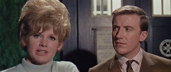 Movie still from “Dr. Who and the Daleks” (1965), directed by Gordon Flemyng – A man and a woman sitting next to each other in a room; Close Up shot, Low angle