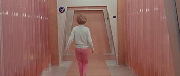 Movie still from “Dr. Who and the Daleks” (1965), directed by Gordon Flemyng – A young child walking down the hall way of an elevator; Wide shot, Low angle
