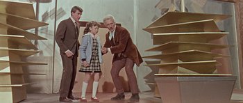 Movie still from “Dr. Who and the Daleks” (1965), directed by Gordon Flemyng – An older man and a little girl in plaid dress; Wide shot, Low angle