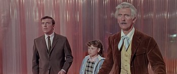 Movie still from “Dr. Who and the Daleks” (1965), directed by Gordon Flemyng – Two men and a little girl standing next to each other; Medium shot, Low angle