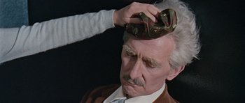 Movie still from “Dr. Who and the Daleks” (1965), directed by Gordon Flemyng – An older man getting his hair combed by an older woman; Close Up shot, High angle