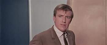 Movie still from “Dr. Who and the Daleks” (1965), directed by Gordon Flemyng – A person wearing a suit and tie; Close Up shot, Low angle