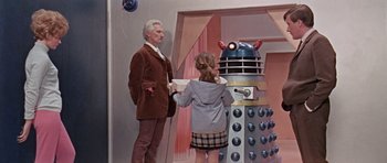 Movie still from “Dr. Who and the Daleks” (1965), directed by Gordon Flemyng – A young girl and an older man in front of a dalek; Medium shot, Low angle