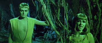 Movie still from “Dr. Who and the Daleks” (1965), directed by Gordon Flemyng – A person touching a plant in a dark room; Medium shot, Over the shoulder angle