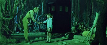 Movie still from “Dr. Who and the Daleks” (1965), directed by Gordon Flemyng – A young girl is shaking hands with an older man; Wide shot, Over the shoulder angle