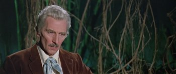 Movie still from “Dr. Who and the Daleks” (1965), directed by Gordon Flemyng – An older man in a suit and a tie; Close Up shot, Over the shoulder angle