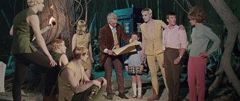 Movie still from “Dr. Who and the Daleks” (1965), directed by Gordon Flemyng – A group of young people dressed up in costumes; Medium shot, High angle