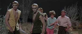 Movie still from “Dr. Who and the Daleks” (1965), directed by Gordon Flemyng – A group of people standing next to each other in a field; Medium shot, High angle