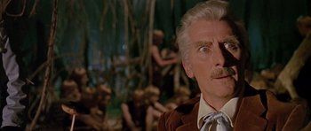 Movie still from “Dr. Who and the Daleks” (1965), directed by Gordon Flemyng – An older man in a suit and bow tie; Close Up shot, Low angle