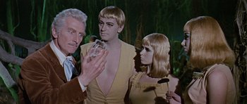 Movie still from “Dr. Who and the Daleks” (1965), directed by Gordon Flemyng – A man and two women standing next to each other; Medium shot, Over the shoulder angle