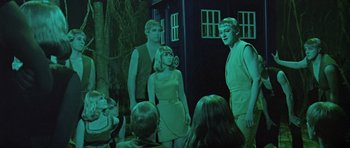 Movie still from “Dr. Who and the Daleks” (1965), directed by Gordon Flemyng – A group of people standing in front of a building; Medium shot, Low angle