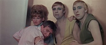 Movie still from “Dr. Who and the Daleks” (1965), directed by Gordon Flemyng – A group of men and a woman posing for a picture; Medium shot, High angle