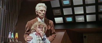Movie still from “Dr. Who and the Daleks” (1965), directed by Gordon Flemyng – An old man and a young girl are posing for a picture; Medium shot, Over the shoulder angle