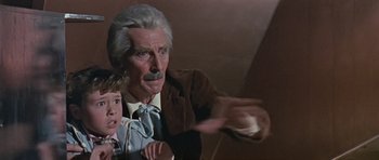 Movie still from “Dr. Who and the Daleks” (1965), directed by Gordon Flemyng – An older man pointing at a young boy; Medium shot, Low angle