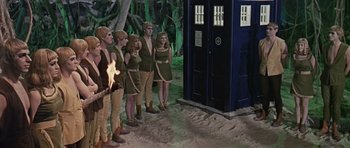 Movie still from “Dr. Who and the Daleks” (1965), directed by Gordon Flemyng – A group of people standing next to each other in front of a tardis; Wide shot, High angle