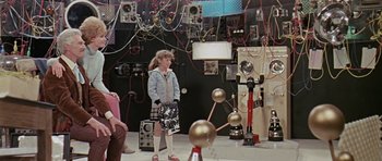 Movie still from “Dr. Who and the Daleks” (1965), directed by Gordon Flemyng – A young girl standing in front of a room filled with electronics; Wide shot, Over the shoulder angle