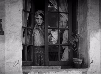 Movie still from “Dracula” (1931), directed by Tod Browning – Two people looking out of a window in an old house; Medium shot, Low angle