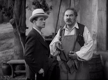 Movie still from “Dracula” (1931), directed by Tod Browning – A man in a suit and a man in a hat standing next to each other; Medium shot, Low angle