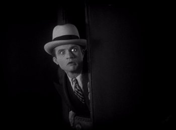 Movie still from “Dracula” (1931), directed by Tod Browning – A black and white photo of a man wearing a hat; Medium shot, Low angle