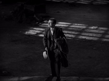 Movie still from “Dracula” (1931), directed by Tod Browning – A black and white photo of a man in a suit and tie; Wide shot, High angle