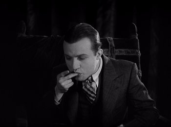 Movie still from “Dracula” (1931), directed by Tod Browning – A black and white photo of a man in a suit eating something; Medium shot, Low angle
