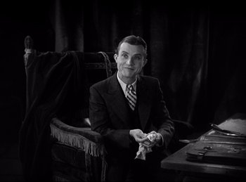 Movie still from “Dracula” (1931), directed by Tod Browning – A black and white photo of a man sitting at a table; Medium shot, High angle