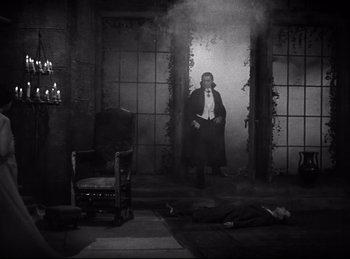 Movie still from “Dracula” (1931), directed by Tod Browning – A man standing in a room next to a chair and a fire hydrant; Wide shot, High angle