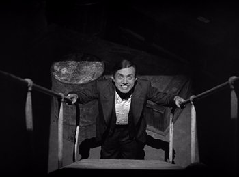 Movie still from “Dracula” (1931), directed by Tod Browning – A black and white photo of a man in a suit and tie; Medium shot, Overhead angle