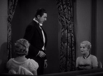 Movie still from “Dracula” (1931), directed by Tod Browning – A black and white photo of a man and two women in front of a mirror; Medium shot, High angle