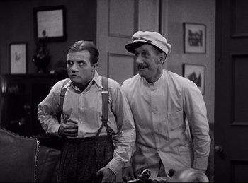 Movie still from “Dracula” (1931), directed by Tod Browning – A couple of men standing next to each other in a room; Medium shot, Low angle