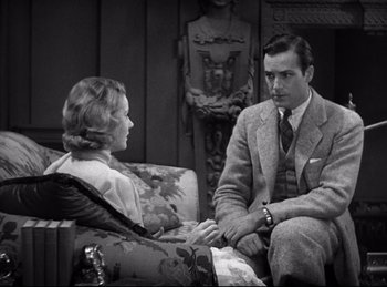 Movie still from “Dracula” (1931), directed by Tod Browning – A man and a woman sitting on a couch talking to each other; Medium shot, High angle