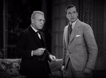 Movie still from “Dracula” (1931), directed by Tod Browning – Two men in suits standing next to each other in a room; Medium shot, High angle