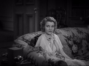 Movie still from “Dracula” (1931), directed by Tod Browning – A woman sitting on top of a couch in a living room; Close Up shot, High angle