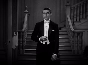 Movie still from “Dracula” (1931), directed by Tod Browning – A man in a tuxedo standing in front of a staircase; Medium shot, Low angle
