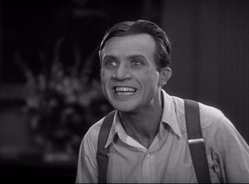 Movie still from “Dracula” (1931), directed by Tod Browning – An older man smiling with braces and suspenders; Close Up shot, Low angle