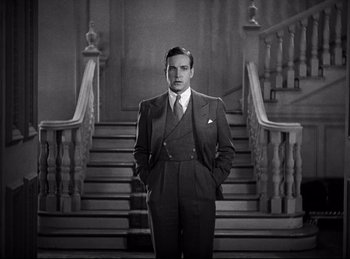 Movie still from “Dracula” (1931), directed by Tod Browning – A black and white photo of a man standing in front of stairs; Medium shot, Low angle
