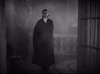 Movie still from “Dracula” (1931), directed by Tod Browning – A black and white photo of a man in a long coat; Wide shot, Low angle