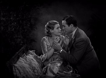 Movie still from “Dracula” (1931), directed by Tod Browning – A man and a woman sitting next to each other on a bed; Medium shot, Overhead angle