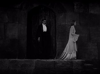 Movie still from “Dracula” (1931), directed by Tod Browning – A man and a woman are standing in front of a door; Wide shot, Low angle